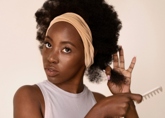 Young Black Lady using Natural Hair Serum for Curly Hair